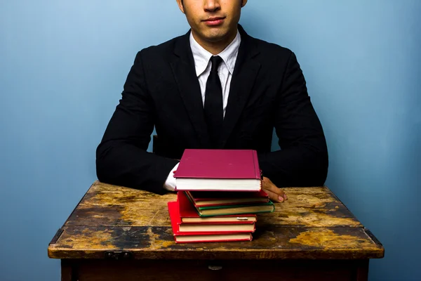 Businessman with stack of books — Stock Photo, Image