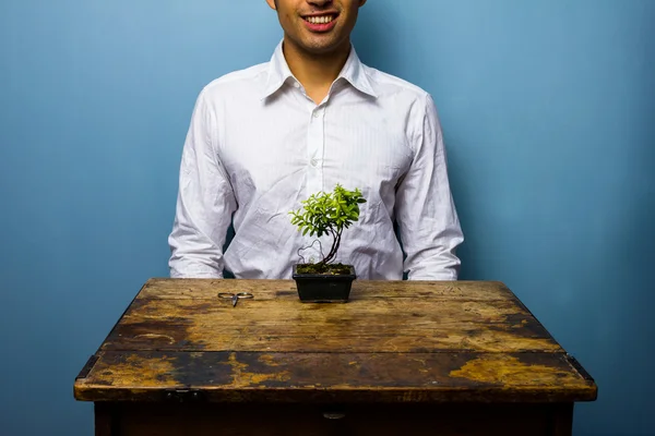 Homem feliz cuidando de uma árvore bonsai — Fotografia de Stock