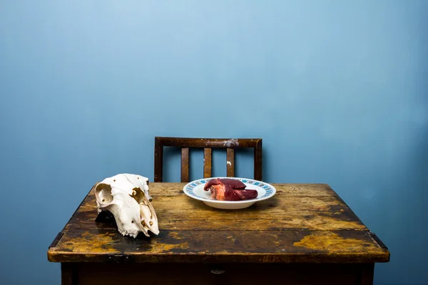 Geit schedel en hart op onl houten bureau — Stockfoto