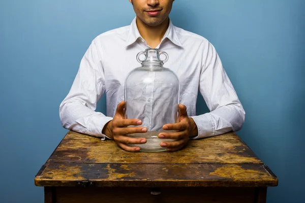 Man met grote lege glazen pot — Stockfoto