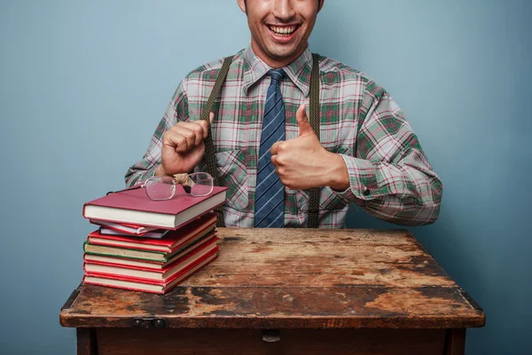 Geek man ger tummen upp på böcker — Stockfoto