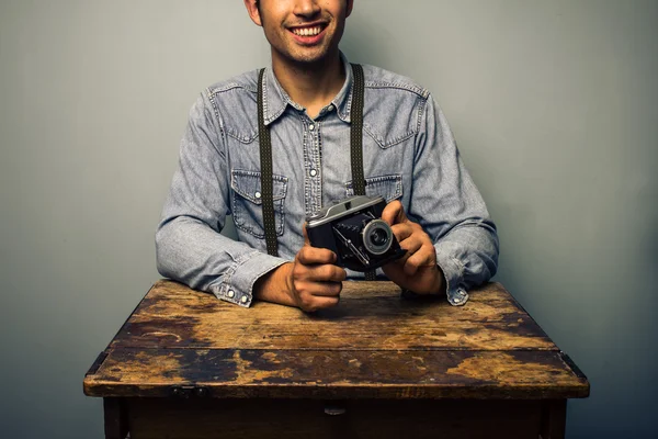 Hipster with vintage camera at old desk — Stock Photo, Image
