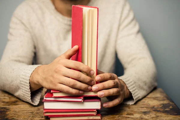 Homem à mesa com livros — Fotografia de Stock