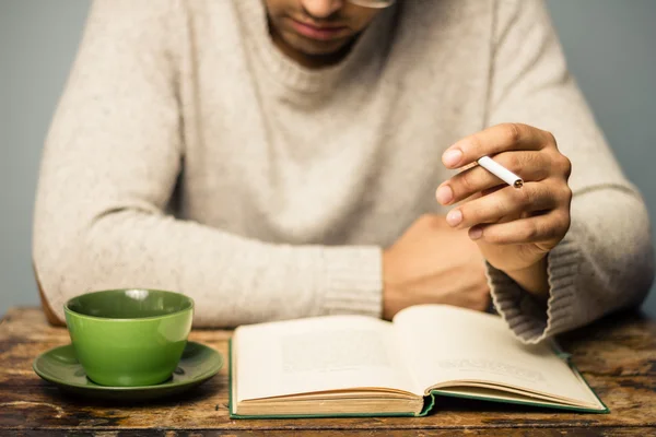 El hombre está leyendo y fumando en la cafetería —  Fotos de Stock