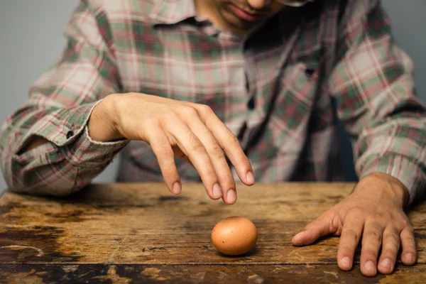 Man spinning an egg on the table — Stock Photo, Image