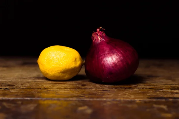 Zitrone und Zwiebel auf hölzerner Oberfläche — Stockfoto