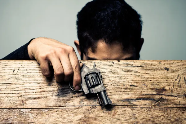 Estudante na mesa da escola com detalhes da arma — Fotografia de Stock