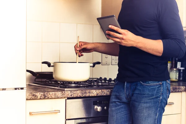 Man following recipe on digital reader — Stock Photo, Image