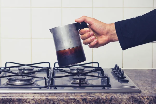 Man's hand plaatsen van espresso maker op fornuis — Stockfoto