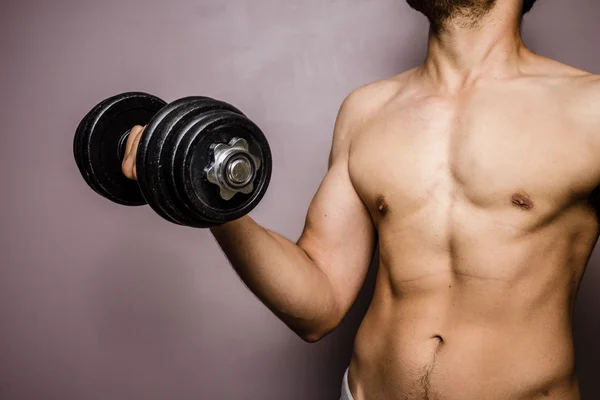 Fit young bodybuilder training with dumbbell — Stock Photo, Image