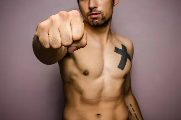 Young man with muscular physique punching — Stock Photo, Image