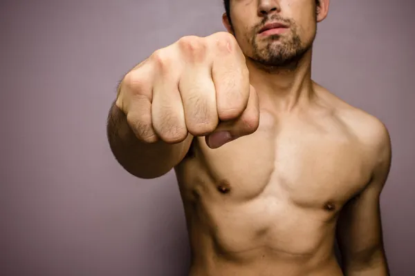 Young man with muscular physique punching — Stock Photo, Image