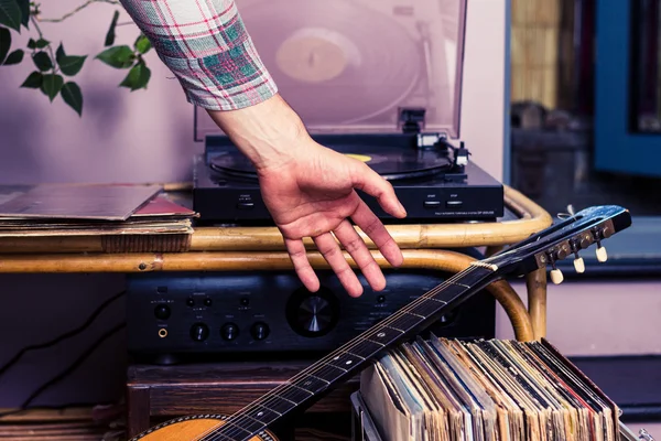 Man oppakken van gitaar na het beluisteren van records — Stockfoto