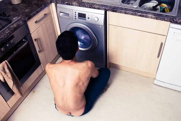 Giovane uomo guardando il ciclo di lavaggio — Foto Stock