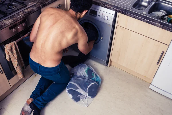 Hombre cargando su lavadora — Foto de Stock