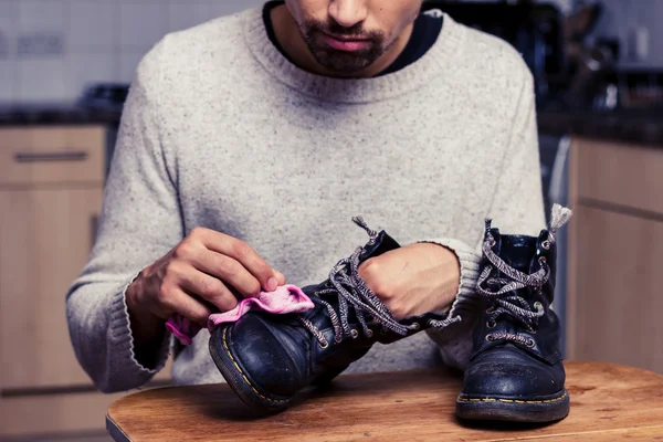 O homem está a polir as botas. — Fotografia de Stock