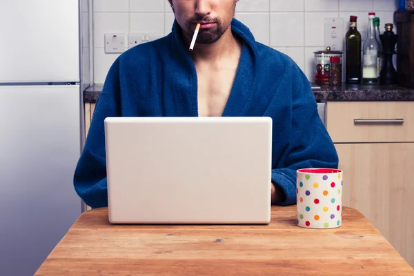 Hombre en bata trabajando desde casa y fumando — Foto de Stock