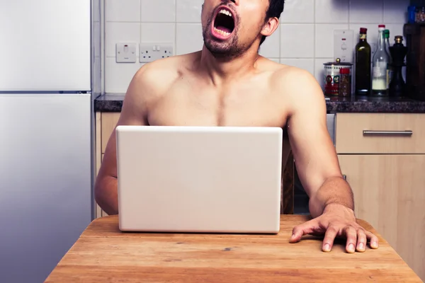 Mladý nahý muž sleduje pornografii v jeho kuchyni — Stock fotografie