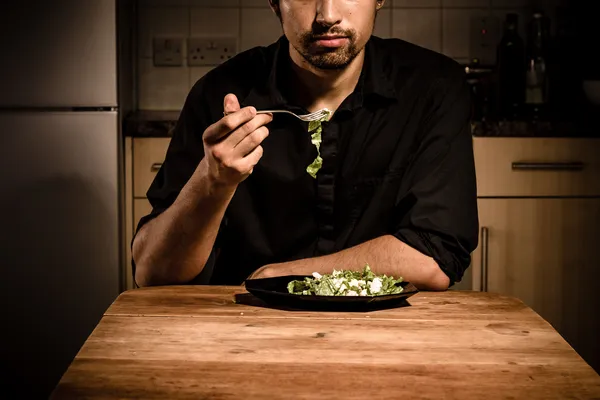 Jovem solteiro comendo seu jantar — Fotografia de Stock