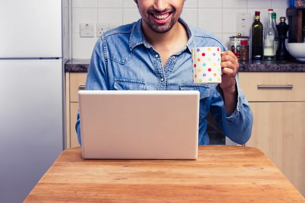 Lycklig man arbetar på sin bärbara dator hemma — Stockfoto