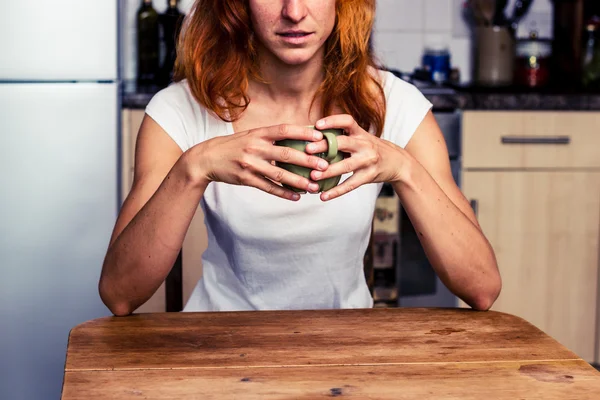 Mujer bebiendo de la taza en su cocina — Foto de Stock