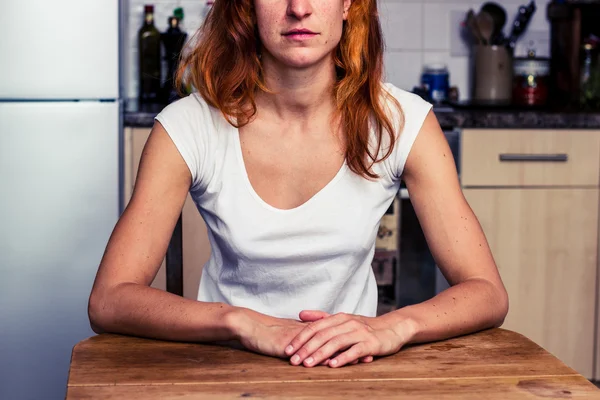 Mujer tranquila sentada en su cocina — Foto de Stock