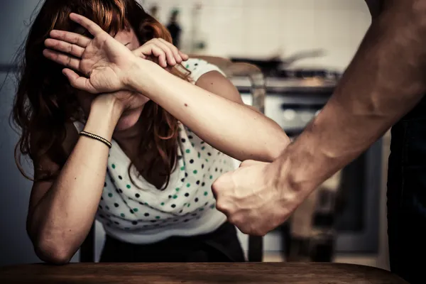 Donna che si copre il volto nel timore della violenza domestica Immagine Stock
