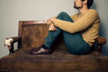 Young man thinking on the couch clipart