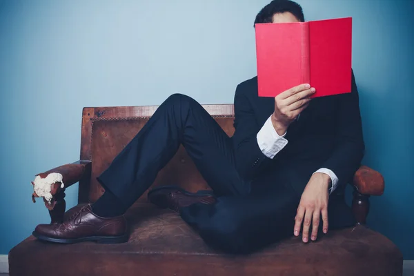 Affärsman på soffa läser — Stockfoto