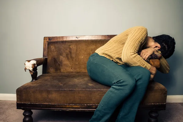 Tired and depressed man hanging off the side of sofa — Stock Photo, Image