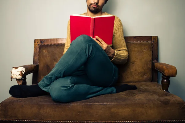 Jonge man lezen op oude Bank — Stockfoto