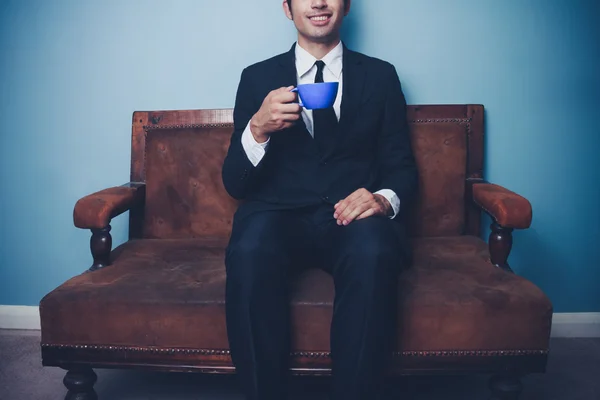 Счастливый молодой бизнесмен пьет кофе — стоковое фото