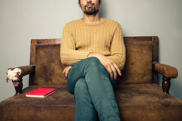 Jonge man zit op oude bank met boek — Stockfoto