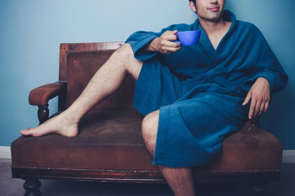 Man relaxing on vintage sofa with cup of coffee — Stock Photo, Image