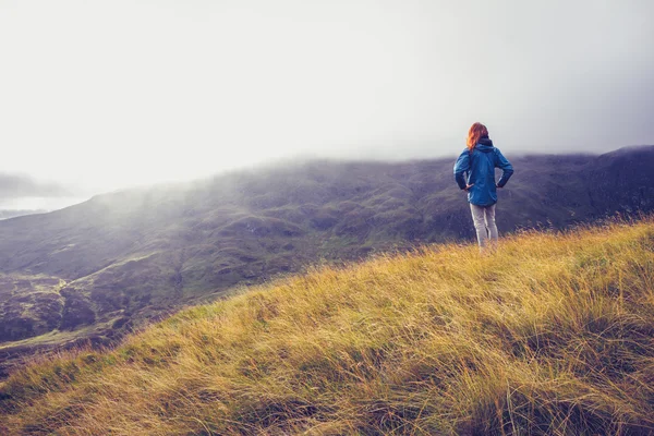 Mujer de pie en la cima de una montaña — Foto de Stock
