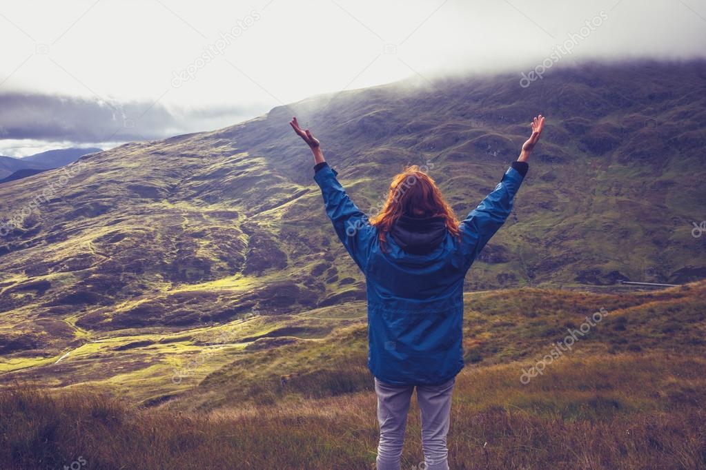 Young woman being one with nature on mountain top