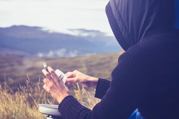 Mujer está cocinando con una estufa portátil en la naturaleza — Foto de Stock