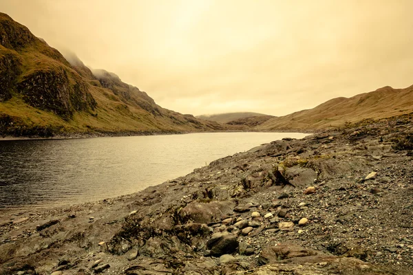 Somber en donker uitzicht op een Schotse loch en bergen — Stockfoto