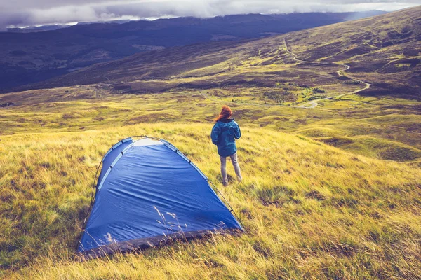 Wild kamperen op de met gras begroeide bergtop vrouw — Stockfoto