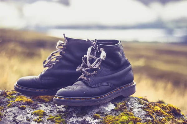 Pair of old boots on a rock in the mountains — Stock Photo, Image