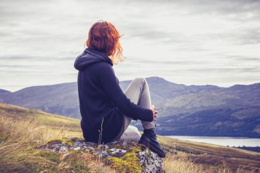 Woman relaxing on mountain top clipart