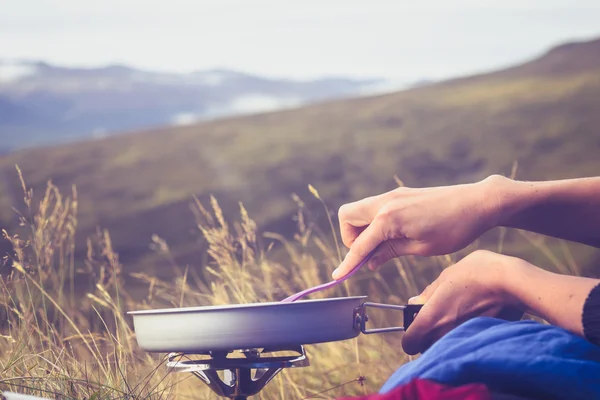 Gros plan sur la cuisson des mains sur le poêle portable dans la nature — Photo