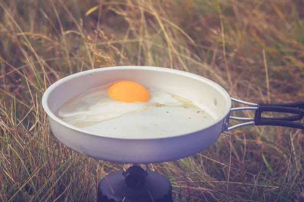 Fritura de ovo na panela no fogão de campismo portátil ao ar livre — Fotografia de Stock