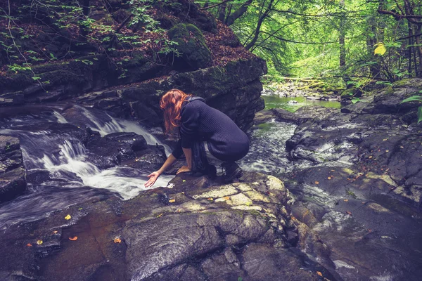 Woman washing her hands in mountain stream — Stock Photo, Image