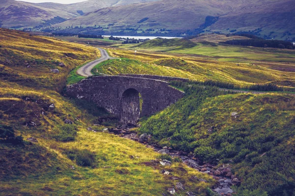 Old stone bridge in rural mountain landscape — Stock Photo, Image