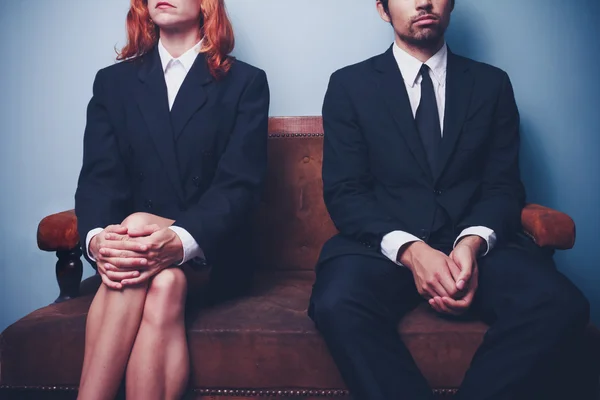 Geschäftsmann und Frau warten auf Sofa in Lobby — Stockfoto