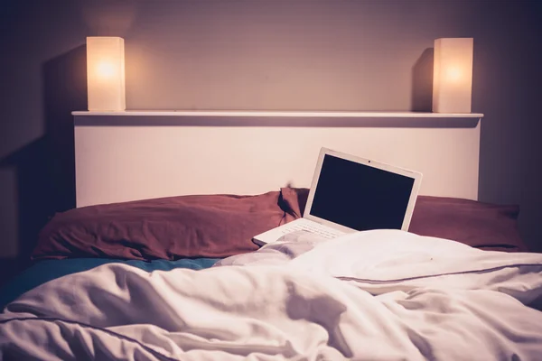 Přenosný počítač v posteli v noci — Stock fotografie