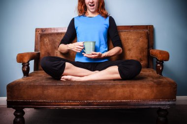 sakinleştirici çay içme koltukta oturan genç manevi kadın