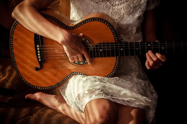 Junge Frau spielt Gitarre mit Schatten von Jalousien — Stockfoto