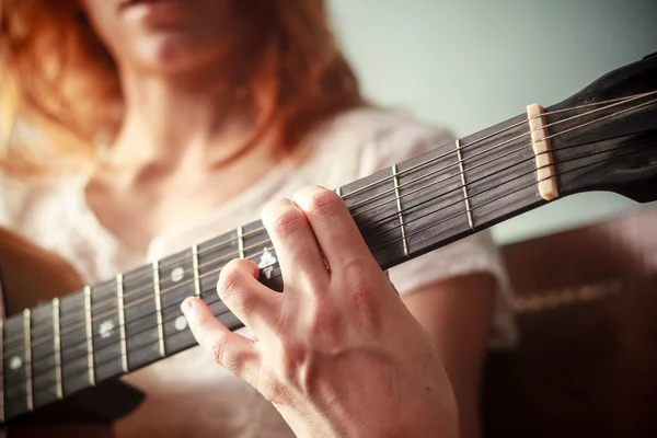 Close up on young woman's hand playing guitar — Stock Photo, Image